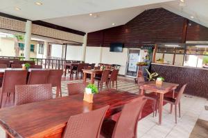 a restaurant with tables and chairs and a dining room at Estaca Bay Gardens Conference Resort powered by Cocotel in Compostela
