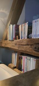 a row of books sitting on a wooden shelf at Au Lampadaire Briarois in Briare