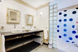 a bathroom with two sinks and a shower at Villa Vue-Belle in Saint-Paul