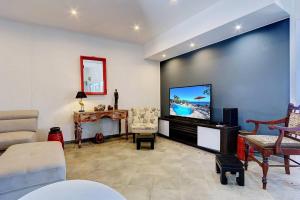 a living room with a flat screen tv on a wall at Villa Vue-Belle in Saint-Paul