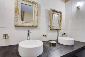 a white bathroom with a sink and a mirror at Villa Vue-Belle in Saint-Paul