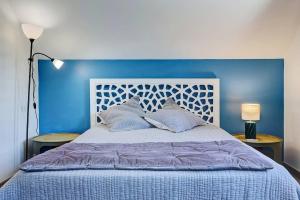a blue bedroom with a bed with a blue headboard at Villa Vue-Belle in Saint-Paul