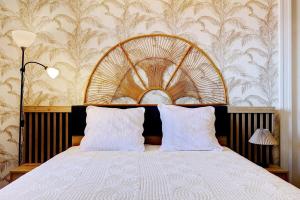a bedroom with a large bed with a wooden headboard at Villa Vue-Belle in Saint-Paul