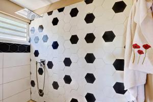 a bathroom with black and white hexagonal tiles on the wall at Villa Vue-Belle in Saint-Paul