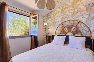 a bedroom with a large bed with a large window at Villa Vue-Belle in Saint-Paul