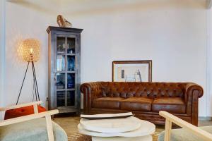 a living room with a brown couch and a table at Villa Vue-Belle in Saint-Paul