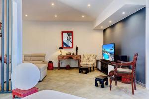 a living room with a couch and a tv at Villa Vue-Belle in Saint-Paul