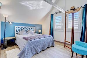 a blue bedroom with a bed and a blue chair at Villa Vue-Belle in Saint-Paul