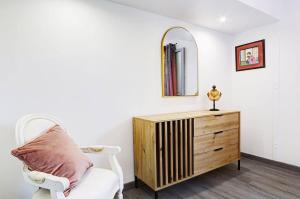 a room with a chair and a dresser and a mirror at Villa Vue-Belle in Saint-Paul