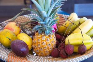 a basket of fruit with a pineapple and other fruits at Villa Vue-Belle in Saint-Paul