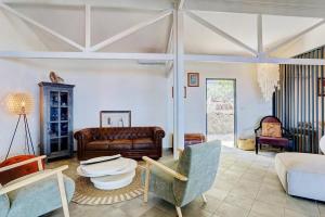 a living room with a couch and a table and chairs at Villa Vue-Belle in Saint-Paul