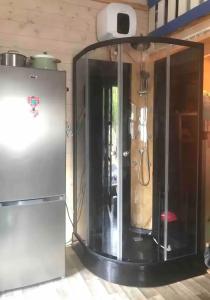a refrigerator in a room with a light above it at Tiny House - La Foret du Dragon in Murols +28 photos