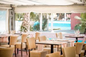 a restaurant with tables and chairs and a pool at Malibu Village in Canet-en-Roussillon
