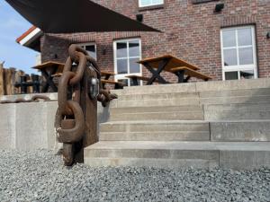 a chain attached to a set of stairs in front of a building at stilfrei by Humble Homes in Carolinensiel