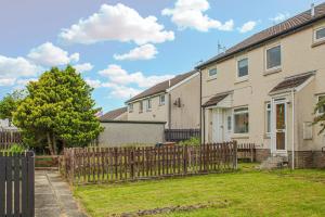 a row of houses with a wooden fence at 1-Bed Home in Lanarkshire with Free Parking - Long Stays Available in Newarthill