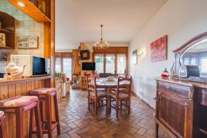 a kitchen and dining room with a table and chairs at Can Mussol in Sant Hilari Sacalm