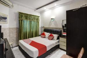 a bedroom with a bed and a dresser and a mirror at Hotel O Manisee 1 Homestay Syariah in Tanjunguma
