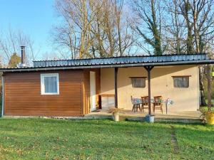 a small house with a table in front of it at Gite le Martin Pêcheur au bord du Canal de l'Est in Champneuville