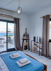 a room with a bed with two towels on it at Beachfront Blue Comfort Sitia By ComfortBnb in Sitia