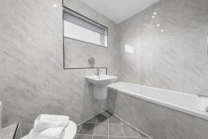 a bathroom with a sink and a tub and a toilet at 1-Bed Home in Lanarkshire with Free Parking - Long Stays Available in Newarthill +24 photos