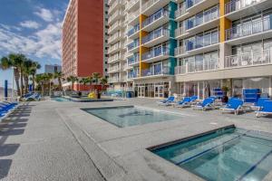un complejo de apartamentos con piscina, sillas y un edificio en Atlantica 601, en Myrtle Beach