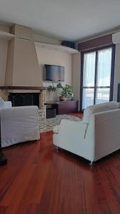 a living room with two white couches and a fireplace at Casa Vanessa Appartamento in Villa in Pieve Emanuele