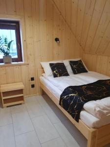 a bedroom with a bed in a wooden room at Osada Bajka in Murzasichle