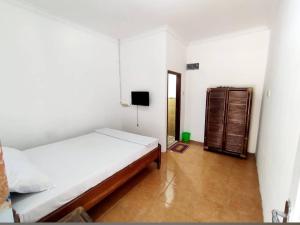 a bedroom with two beds and a television in it at HENDRO'S SURF CAMP Pulau merah in Pasanggaran