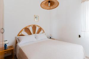 a bedroom with a white bed with a wooden headboard at Casa Vacanze Irene - Salento Selection in Torre Lapillo