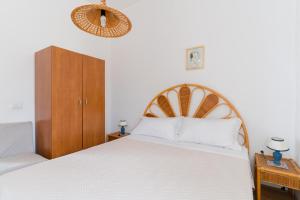 a bedroom with a large bed with a wooden headboard at Casa Vacanze Irene - Salento Selection in Torre Lapillo