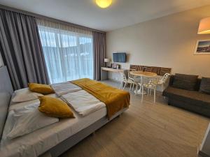 a bedroom with a bed and a table and a couch at Czarna Góra Resort, Apartament z widokiem na góry, Stubai in Biała Woda