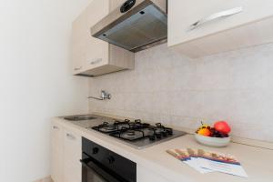 a kitchen with a stove and a bowl of fruit at Casa Vacanze Irene - Salento Selection in Torre Lapillo