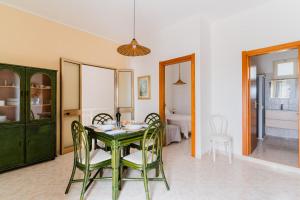a dining room with a green table and chairs at Casa Vacanze Irene - Salento Selection in Torre Lapillo