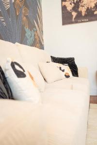 a white couch with pillows on it in a room at Appartement Stylé pour 4 in Châlons-en-Champagne +32 photos