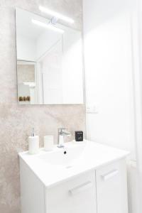 a white bathroom with a sink and a mirror at Appartement Stylé pour 4 in Châlons-en-Champagne