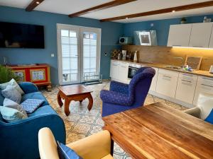 a living room with two blue chairs and a table at Dat Smucke Reethus Erdgeschoss in Born