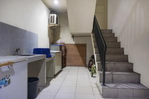 a kitchen with a staircase and a stair case at Hotel O Royani Residence in Jakarta