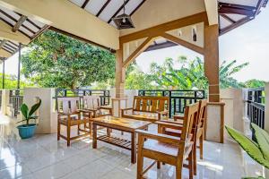 a patio with a table and chairs on a balcony at OYO 91261 Cita Suraya Homestay in Banyuwangi +24 photos