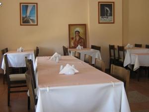 a dining room with white tables and chairs and a painting at Alize Hotel in Göcek