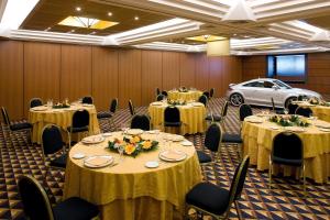 une salle de banquet avec des tables et des chaises ainsi qu'une voiture dans l'établissement Ramada by Wyndham Naples, à Naples