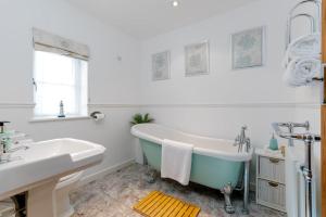 een badkamer met een bad en een wastafel bij Littlecot in Weymouth +35 foto's