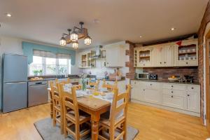 een keuken met een tafel, stoelen en een koelkast bij Littlecot in Weymouth