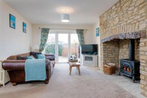 een woonkamer met een bank en een stenen open haard bij Littlecot in Weymouth