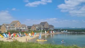 een strand met een aantal zeilboten op het water bij Littlecot in Weymouth