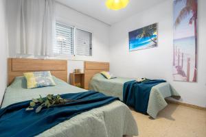Un dormitorio con dos camas con sábanas azules. en Apartamento Bell Raco, en La Pineda