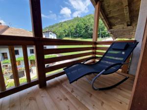 a blue chair sitting on a wooden deck with a view at Casa Campetta in Comano Terme +39 photos