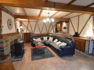 a living room with a black leather couch and a fireplace at Spacious holkiday home in Mettet with large garden in Mettet