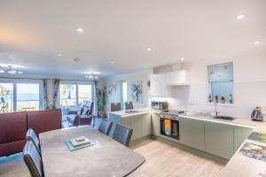 eine Küche und ein Wohnzimmer mit Tisch und ein Esszimmer in der Unterkunft Beach View House - Self Catering Hayle, St Ives Bay Cornwall in Hayle