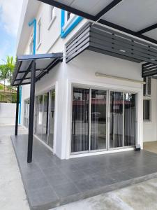 Home Phuket Andaman 3BR في Ban Klang: مبنى به مظلات على جانبه +3 صور