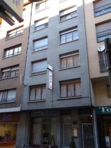 un grand bâtiment gris avec balcon dans une rue dans l'établissement Residència Restaurant Indalo, à Andorre-la-Vieille